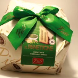 Panettone Pistì à la pistache, recouvert de pistaches vertes hachées sur un glaçage au chocolat blanc.