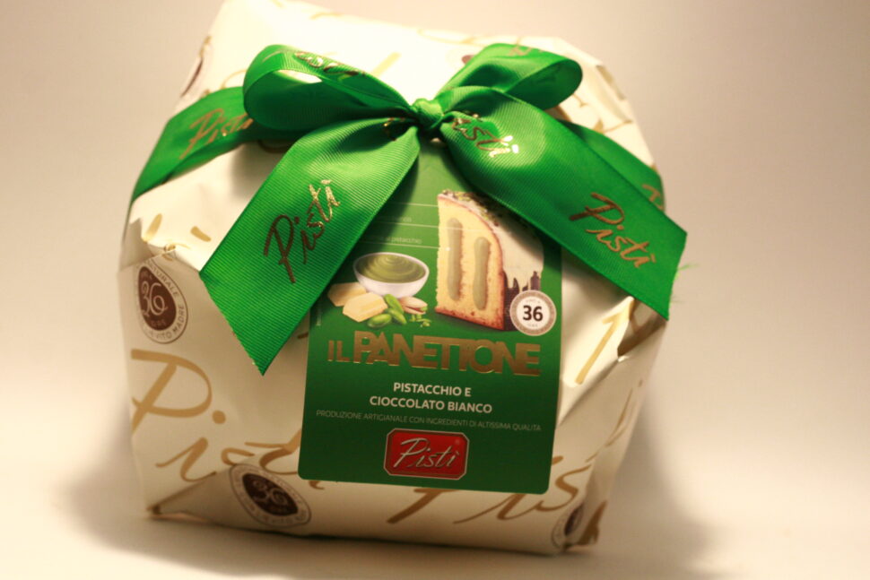 Panettone Pistì with Pistachio, covered with chopped green pistachios on a white chocolate glaze.